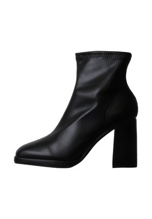 Bottine en cuir noir avec un bout pointu et un talon bloc épais et haut, finition lisse et bordure cousue sur le bord supérieur.
