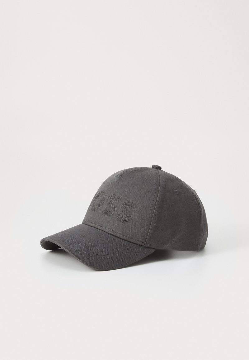 Casquette grise en tissu avec un design structuré. Elle présente un logo brodé à l'avant et une visière incurvée.