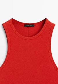 Rød ribbet tanktop med rund halsudskæring og brede armlufthuller. Etiketten siger "Massimo Dutti," med syninger der matcher stoffarven.