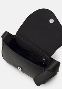 Czarna skórzana torebka z klapką na zapięcie, srebrnym zatrzaskiem i gładką podszewką wewnętrzną. Wewnątrz znajduje się kieszeń na suwak.