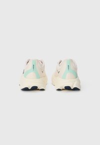 Lightweight sneakers featuring a cream mesh upper, soft mint accents, pink details at the heel, and a textured cream sole with dark rubber elements.
