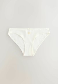 Sous-vêtement blanc en coton style bikini avec un petit nœud décoratif et un emblème doré du soleil au centre de la ceinture sur fond clair.