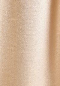 Tessuto beige con una texture liscia e leggermente riflettente, caratterizzato da una leggera lucentezza. La superficie presenta un intreccio fine e uniforme.