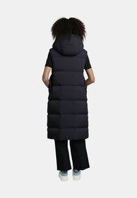 Gilet imbottito lungo di colore blu navy scuro con cappuccio, caratterizzato da sezioni trapuntate, tasche laterali e una vestibilità comoda, mostrato dalla parte posteriore.