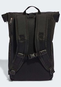 Svart ryggsäck med vadderad mesh-bakpanel, justerbara axelremmar, bröstspänne och bärhandtag upptill mot en ljus bakgrund.