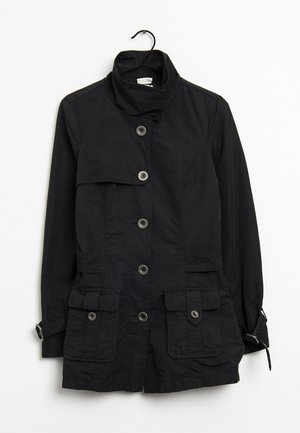 Svart jacka med hög krage, knappfront, två bröstfickor och justerbara manschetter. Tillverkad av lätt tyg med en mjuk yta.