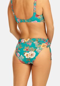 Kwiatowy zestaw bikini z turkusowym tłem, regulowanymi ramiączkami i wiązaniami po bokach dolnej części, ozdobiony kolorowymi wzorami kwiatowymi.