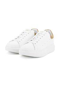 Sneakers bianchi a vita bassa con lacci bianchi, suole spesse e linguette sul tallone a motivo cammello, mostrate da una prospettiva frontale angolata.