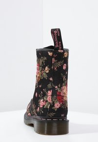 Czarne botki za kostkę z materiałową cholewką, z różowo-zielonym kwiatowym wzorem i kontrastowym różowym przeszyciem na podeszwie.