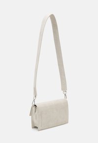 Borsa crema con stampa coccodrillo, a forma rettangolare, con un corpo piatto e una lunga tracolla regolabile, caratterizzata da dettagli in metallo argentato.