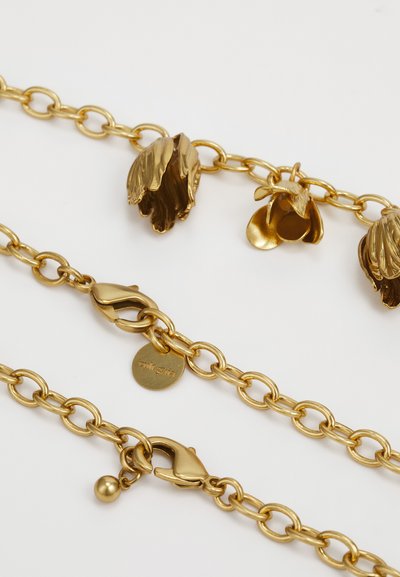 Arany fém lánc nyaklánc virág alakú charmokkal, textúrázott részletekkel és homár kapoccsal, amelyen egy kerek címke található.