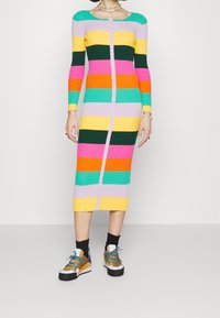 Vestido de punto acanalado multicolor con mangas largas, que presenta rayas horizontales en amarillo, rosa, verde y naranja, con cierre de botones en la parte delantera.