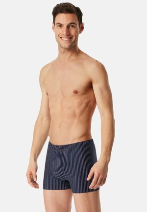 Boxers bleu marine à rayures avec des rayures verticales roses, taille élastique et coupe ajustée. Texture de tissu lisse.
