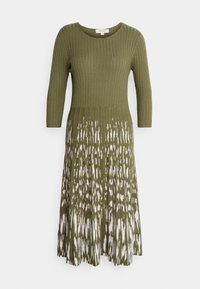 Robe tricotée vert olive avec corsage côtelé, manches 3/4, et motif abstrait blanc sur la jupe évasée. Texture lisse, longueur au genou.