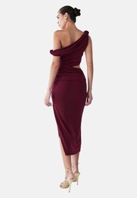 Burgundin midi-mekko, jossa on valuva off-shoulder-suunnittelu, vartalonmyötäinen malli, leikattu yksityiskohta ja sivuisko; käytetään kultaisilla nauhakoroilla.