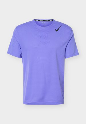 Svetlo vijolična Nike športna majica s kratkimi rokavi, z majhnimi prezračevalnimi luknjami in črnim Nike logotipom na desni strani prsnega koša.