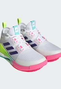 Weiße Sportschuhe mit strukturiertem Obermaterial, lila Streifen und einer mehrfarbigen Sohle in Pink-, Grün- und Blauakzenten.