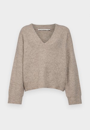 Bežový pletený sveter s výstrihom do V a skráteným dizajnom. Má voľne padnúce rukávy a textúrovaný vzor po celom povrchu.
