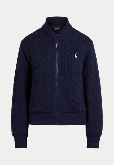 Pull zippé bleu marine en maille torsadée avec col, poignets et bas côtelés, et logo blanc brodé sur la poitrine et la manche.
