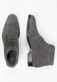 Pair of dark gray suede ankle boots with laces, one showing top view and the other side profile on a white background.