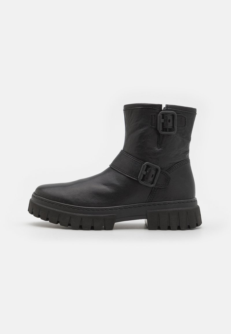 Botas de tobillo de cuero negro con punta redonda, suela de goma gruesa y dos hebillas laterales como detalle. Textura suave con un acabado mate.