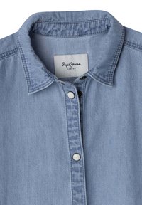 Svijetloplava traper košulja s mekim tekstilom, šiljastim ovratnikom i bijelim dugmadi na prednjoj strani. Oznaka glasi "Pepe Jeans London."