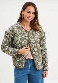 Gestepptes grünes Jacket mit floralem Muster, runder Ausschnitt und Druckknopfverschluss. Lange Ärmel mit kontrastierendem Besatz.
