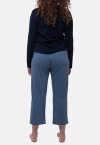 Mörkblå långärmad topp i kombination med ljusblå, korta byxor. Mjuk tyg, avslappnad passform. Byxorna har resårmidja och raka ben.