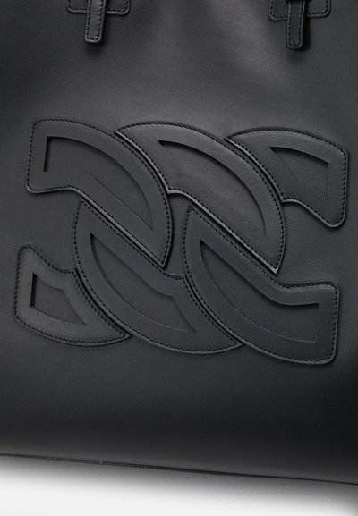 Sac à main en cuir noir avec un motif entrelacé en relief. Texture lisse avec des détails en coutures et deux poignées supérieures.