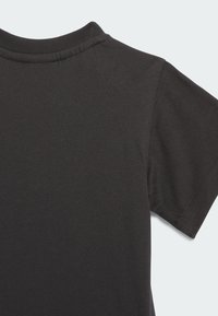 Μαύρο βαμβακερό μπλουζάκι με στρογγυλή λαιμόκοψη και κοντά μανίκια, με λεία υφή και διπλές ραφές στις άκρες για ανθεκτικότητα.