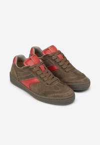 Sneaker in suede marrone con accenti rossi, fodera in tessuto grigio e suola in gomma testurizzata. Presentano un design tradizionale con lacci e dettagli cuciti.