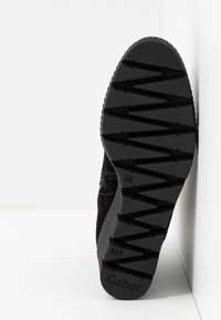 Semelle de chaussure noire avec motif profond en zigzag et nom de marque « Gabor » visible près du talon.