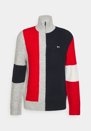 Half-zip knit sweater with vertical red, black, and gray color blocks, crew neck collar, and small logo on the black section.