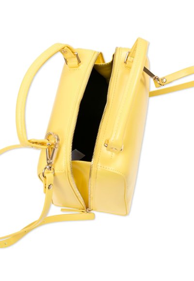 Rumena usnjena torbica z dvema ročajema, odstranljivim trakom za čez ramo in delno odprtim zadrgo, ki razkriva črto notranjost.