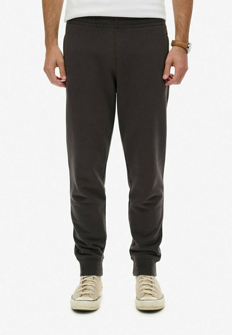 Donkergrijze joggers met een elastische tailleband en omgeslagen enkels. Gemaakt van zachte stof, met zijzakken en een relaxte pasvorm.