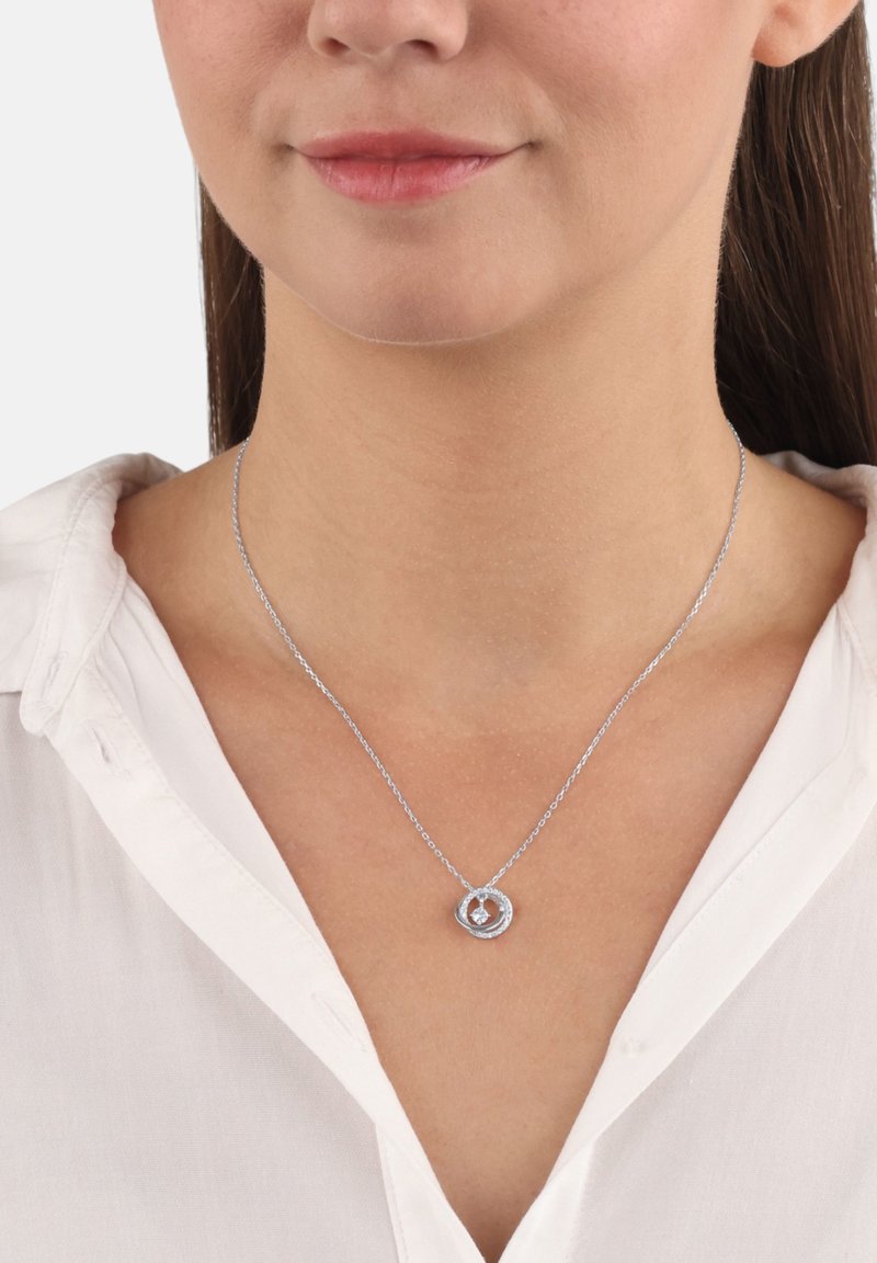 Collana d'argento con un pendente rotondo che presenta una piccola gemma al centro, appesa a una delicata catena.