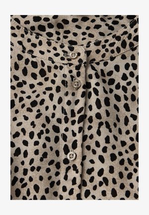 Blusa marrón con estampado animal negro, con una tapeta de botones, escote redondo y textura de tela suave. Los botones son de color claro.