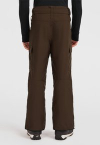 Bruna snöbyxor med en slät yta, som har cargofickor, en bred midja och en något avsmalnande bendesign, som bärs med svarta skor.