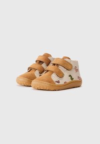Bottines en suède marron avec des côtés beiges ornés d'imprimés de dinosaures colorés. Velcro ajustable et semelles en caoutchouc texturé.