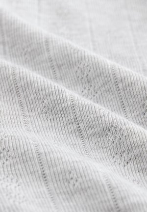 Tissu tricoté gris clair présentant une texture côtelée avec des motifs subtils en forme de losange et des contours, créant un design délicat et complexe.