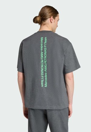 Grijze katoenen t-shirt met een verticale groene tekstlogo op de achterkant. Korte mouwen en een ontspannen pasvorm, met een ronde hals.