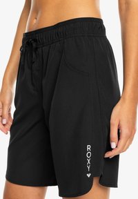 Crne kupaće gaće s elastičnom waistbandom i podesivim vezicom. Sadrži bočne džepove i "ROXY" logo u bijeloj boji na donjem dijelu noge.