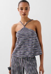 Top multicolore senza spalline con texture a righe orizzontali, caratterizzato da un design annodato all'escursionismo; abbinato a pantaloni a righe coordinati.