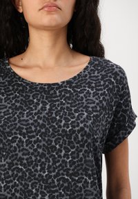 Short-sleeve black T-shirt featuring a gray leopard print pattern, round neckline, soft texture, and relaxed fit.