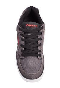 Schwarze Denim-Sneaker mit Schnürdesign, weißer Gummisohle, rotem "Creeks"-Logo auf der Zunge und strukturiertem Stoff-Obermaterial.