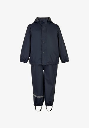 Tuta da pioggia impermeabile blu navy con polsini elasticizzati, cappuccio e dettagli riflettenti. I pantaloni presentano una vita elasticizzata e bretelle regolabili.