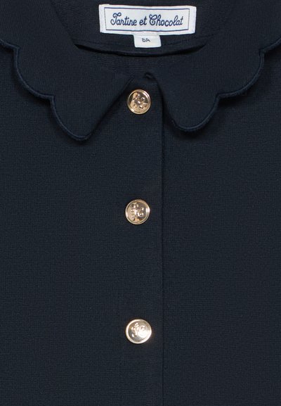 Marinblå strukturerad textil med scallop-krage och tre gyllene dekorativa knappar i mitten, märkt "Tartine et Chocolat".