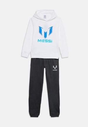 Λευκό φούτερ με μπλε λογότυπο Messi και μαύρη φόρμα με λευκό λογότυπο Messi, απεικονισμένα απλωμένα σε λευκό φόντο.