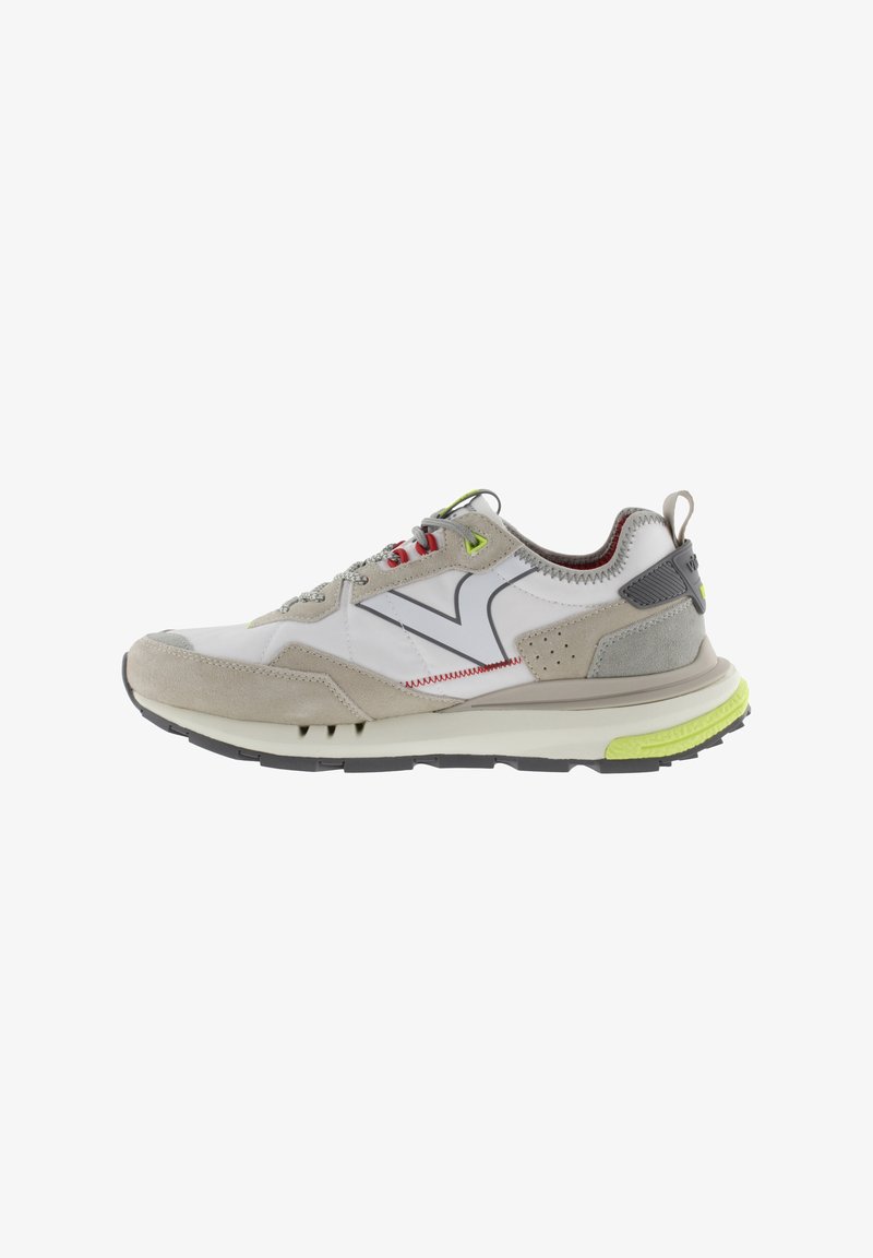 Baskets de sport en cuir blanc et daim gris, avec des accents rouges et verts, une semelle texturée et un logo réfléchissant.