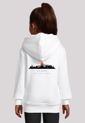 Weißer Kapuzenpullover mit einer schwarzen Silhouette einer Skyline vor einem orangefarbenen Sonnenuntergang, Text mit der Aufschrift "ENTFLIEHEN UND DIE WELT ENTDECKEN."